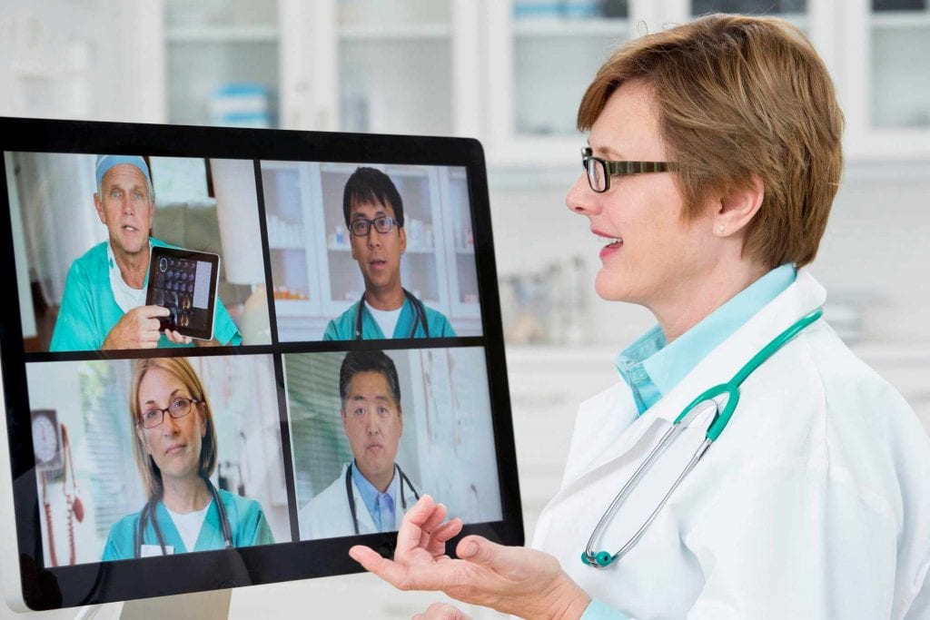 Doctors utilizing teleconferencing technology to work together from remote locations.