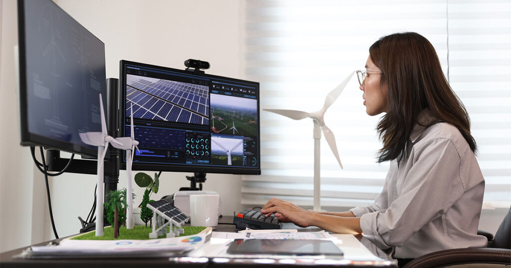 Green Jobs example of woman looking at computer monitor and remotely managing a solar farm 